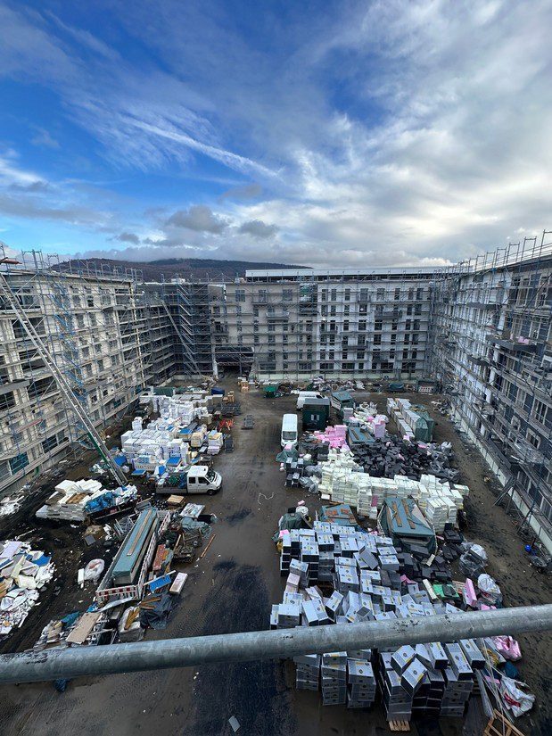 Innenhof der Baustelle mit Dämmplatten und Material für die Fassade